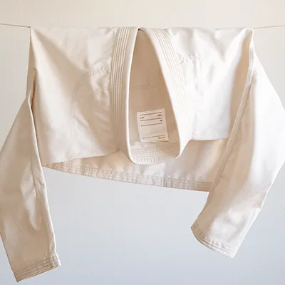 An unbleached gi folded and hanging on a line