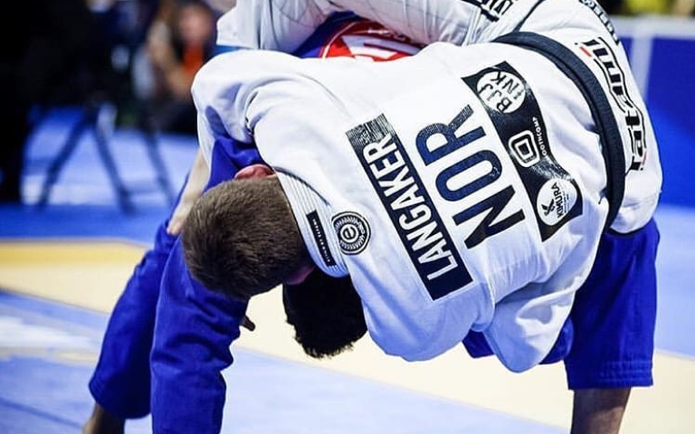 Photo of a BJJ competitor fighing wearing a gi with patches