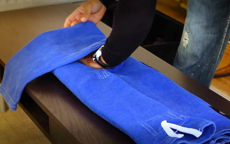 Photo of a person folding a BJJ gi