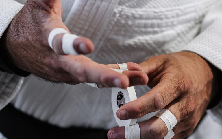 Image of a BJJ practitioner taping his fingers