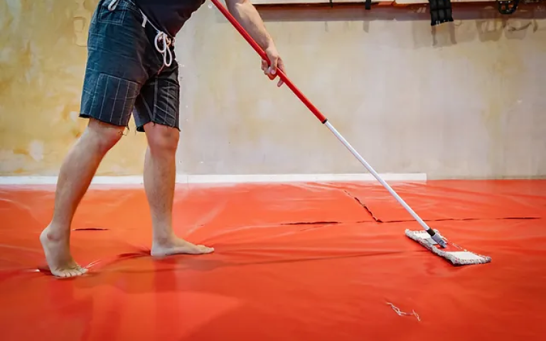 Image of a BJJ athlete cleaning the mats