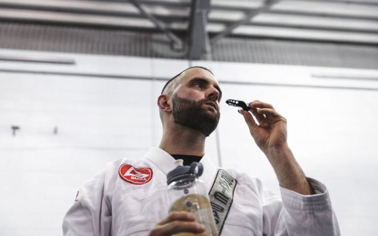 Image of a BJJ practitioner putting on mouthguards